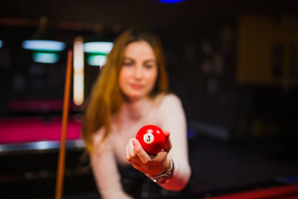 Blue number two billiard ball on a red pool table with other balls in the background
