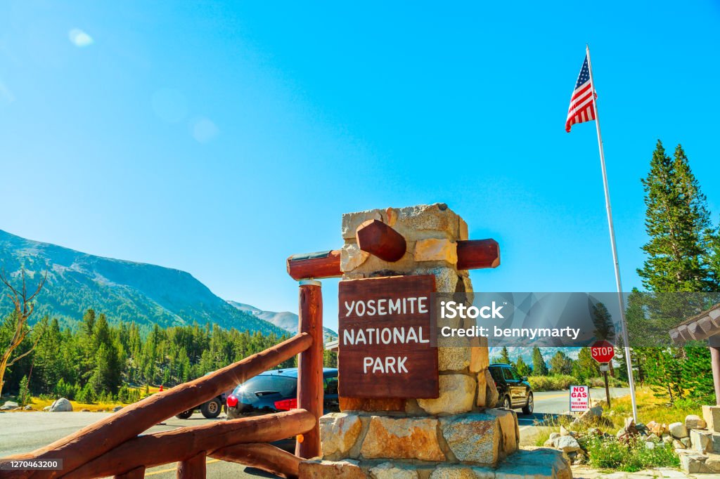 Entrance gate of Yosemite NP Entrance gate with American flag of Yosemite National Park. Summer American holidays in California of United States of America. Yosemite National Park Stock Photo