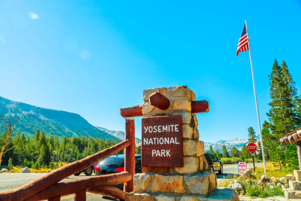 Entrance gate of Yosemite NP Entrance gate with American flag of Yosemite National Park. Summer American holidays in California of United States of America. entrance sign photos stock pictures, royalty-free photos & images