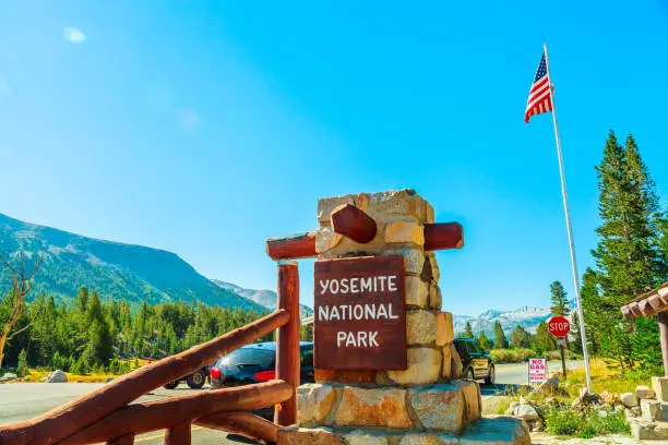 Entrance gate with American flag of Yosemite National Park. Summer American holidays in California of United States of America.