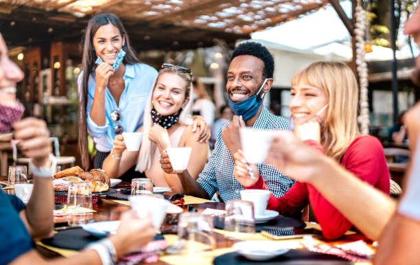 freundesgruppe trinkt cappuccino an der kaffeebar - menschen, die gemeinsam spaß in der cafeteria mit gesichtsmasken haben - neues normales konzept mit glücklichen jungs und mädchen im restaurantcafé - lebendiger kontrastfilter - breakfast eating people teens stock-fotos und bilder