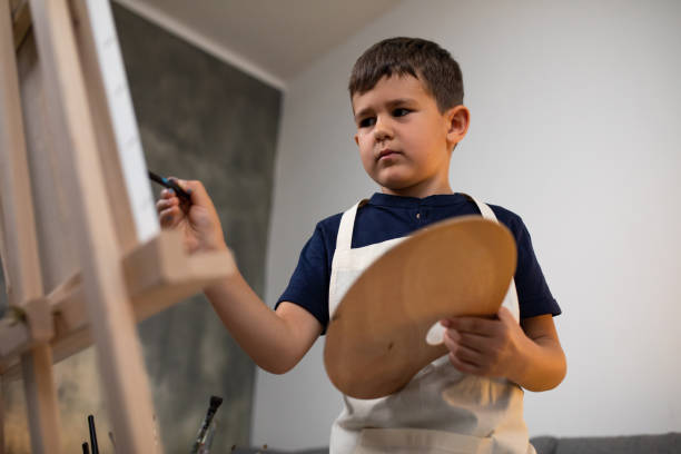 istock A young boy concentrating on painting 1270476665