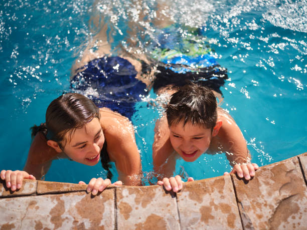 diversión familiar en una piscina al aire libre - early teens child swimming pool swimming fotografías e imágenes de stock