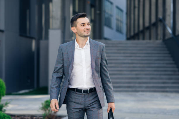 istock Modern businessman. Confident young man in suit looking away while standing outdoors with cityscape in the background. Handsome confident businessman portrait 1270489414