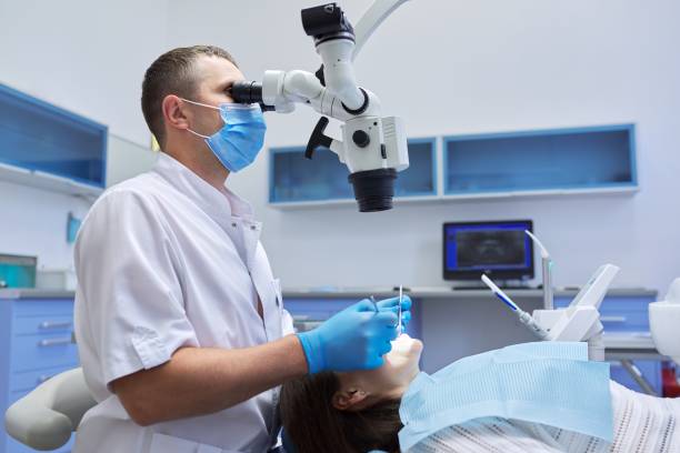 medizinische zahnmedizin, männlicher zahnarzt, der zähne behandelt - dental equipment chair dentist office dentists chair stock-fotos und bilder