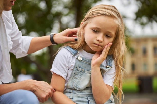 istock Female child holding hand on the face while feeling pain in the teeth 1270493183