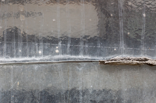 Old and broken sealing puddy between two window pane of structured glass