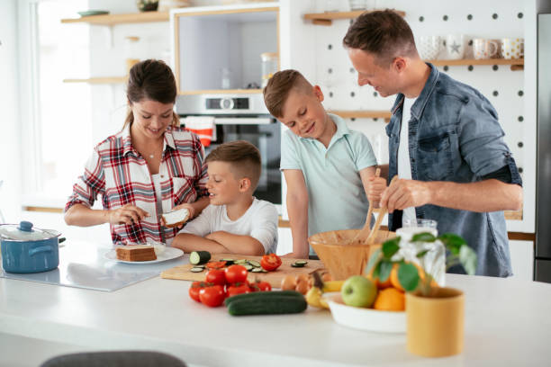 istock Mother and father making breakfast with sons 1270497278