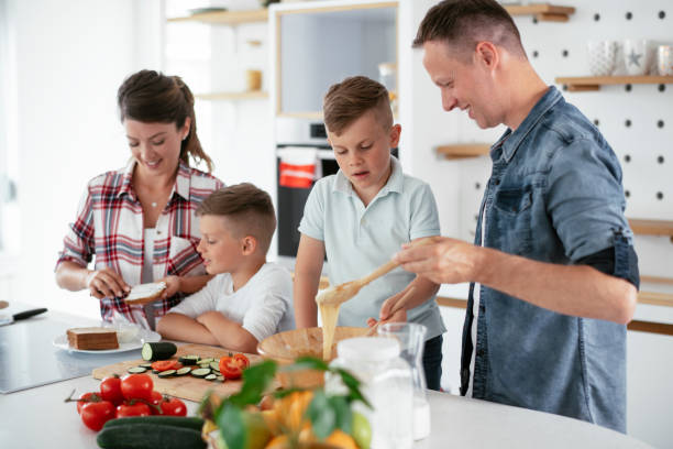 istock Mother and father making breakfast with sons 1270497636