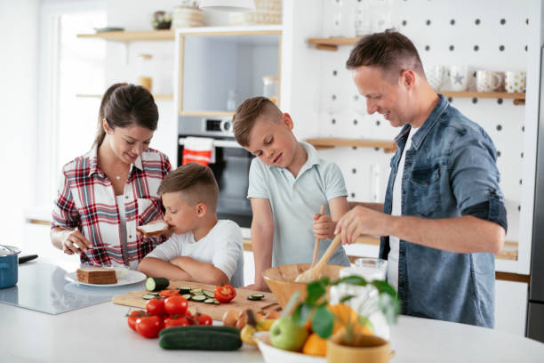 istock Mother and father making breakfast with sons 1270498427