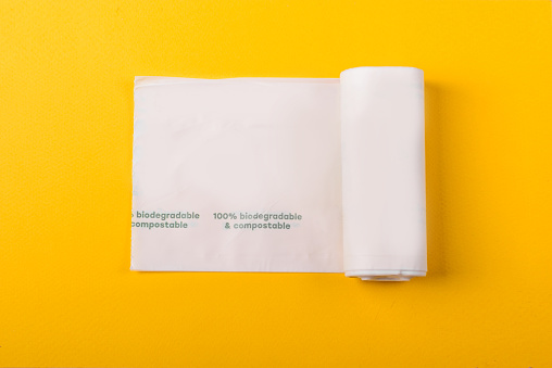 Paquete biodegradable aislado sobre el fondo amarillo. Ecológico. photo