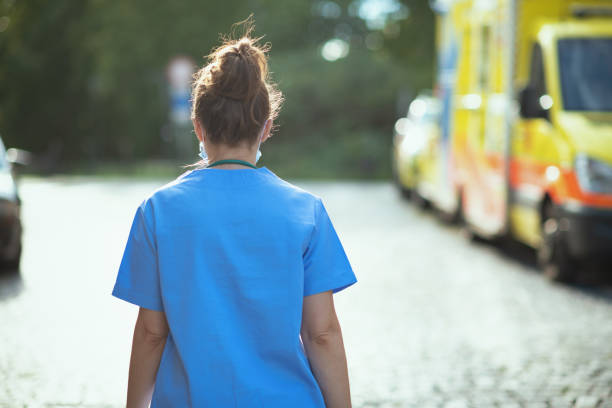 moderne ärztin frau draußen in der nähe von krankenwagen zu fuß - medical occupation flash stock-fotos und bilder