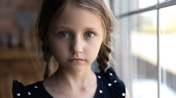 Close up portrait of Caucasian sad little girl Crop close up portrait of serious sad little Caucasian girl look at camera, unhappy small child kid orphan feel lonely abandoned, outcast or loner miss parents, children drama, volunteer concept victim photos stock pictures, royalty-free photos & images