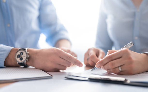 Business people negotiating a contract. Business people negotiating a contract. Human hands working with documents at desk and signing contract. witness signature stock pictures, royalty-free photos & images
