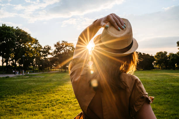 istock Beautiful woman in park at sunset 1270510012