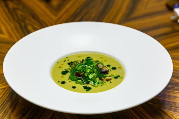 istock Cold cream-soup from cucumbers and greens pour in a white plate 1270510917