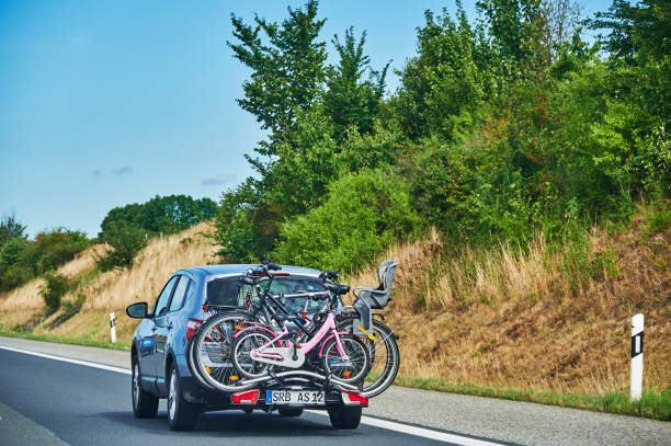 Car with a bike carrier attached to the stern. Freeway 20, Germany - August 30, 2020: Car on the freeway 20 with a bike carrier attached to the stern and bicycles mounted on it. bicycle rack photos stock pictures, royalty-free photos & images