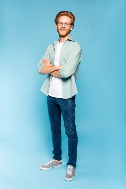 istock redhead and bearded student in glasses standing with crossed arms on blue 1270533045