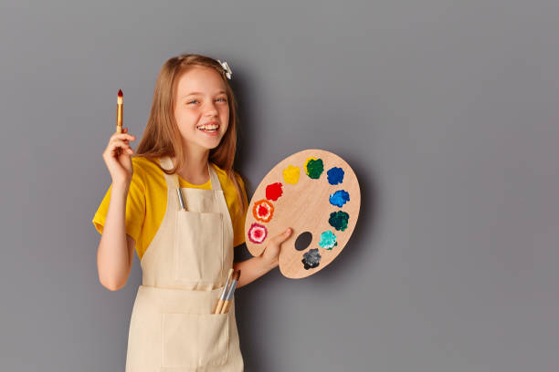 회색 배경에 페인트 팔레트와 브러시 귀여운 행복 한 십대 소녀. - child art paint humor 뉴스 사진 이미지