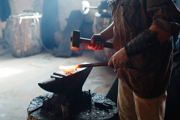 istock Blacksmith working metal with hammer on the anvil in the forge 1270542590