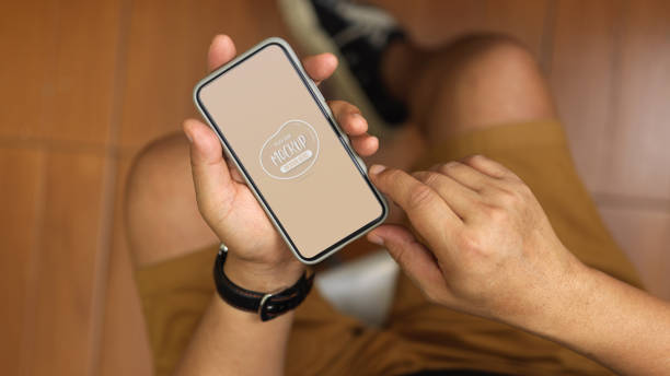 istock Young businessman holding mock up smartphone while sitting in office room 1270547267
