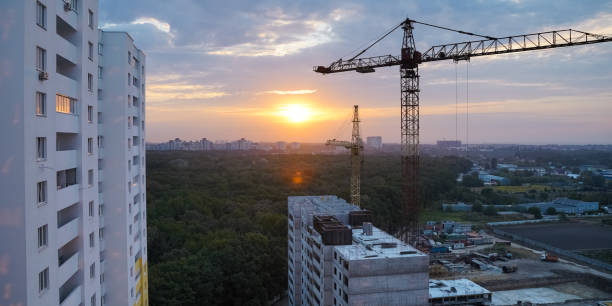 istock View on tower cranes and building construction site at sunrise. 1270549282