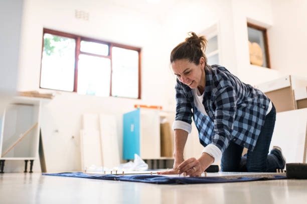 istock Smiling kneeling woman building a kitchen unit 1270549926