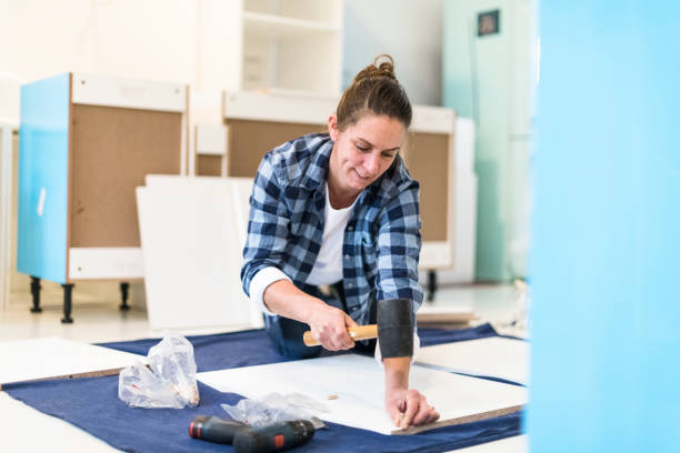 istock Concentrating woman hammering a wooden peg in a board using a rubber mallet 1270549930