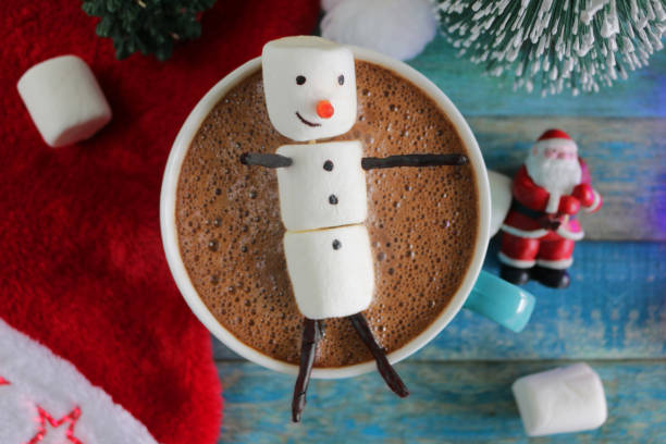 istock Image of group of objects, model Christmas trees, mug hot chocolate drink / cocoa with marshmallow snowman, and red and white Santa hat, turquoise tongue groove effect backdrop, Christmas concept 1270554653