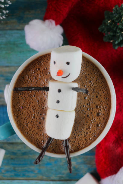 istock Image of group of objects, model Christmas trees, mug hot chocolate drink / cocoa with marshmallow snowman, and red and white Santa hat, turquoise tongue groove effect backdrop, Christmas concept 1270554723