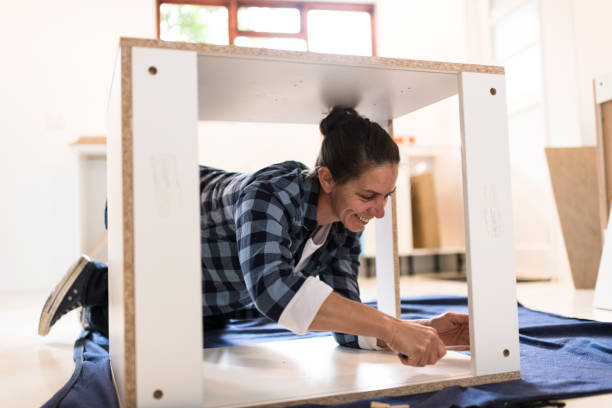 istock Woman inside unfinished cabinet using screwdriver 1270556445