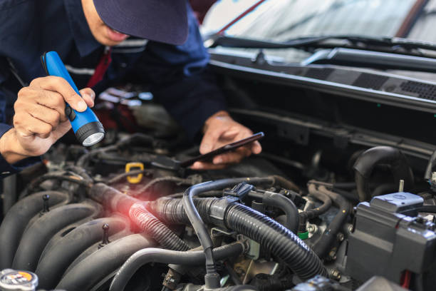 istock Asian Man mechanic inspection Shine a torch car engine checking bug in engine from application smartphone.Red car for service maintenance insurance with car engine.for transport automobile automotive 1270556468