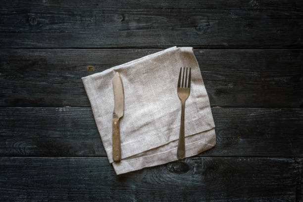 istock Cutlery and napkin on wooden table 1270558655