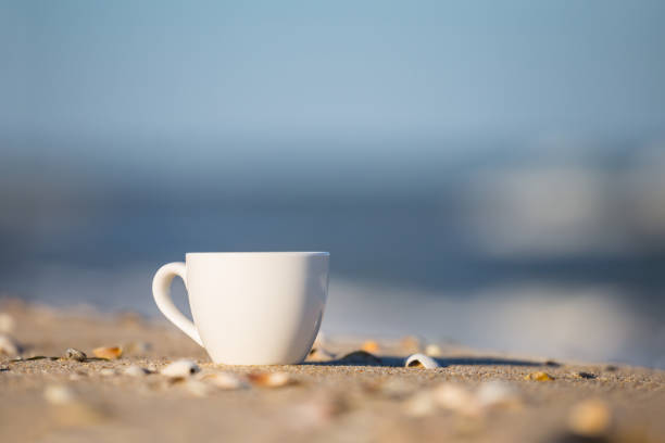 white coffee cup on a sandy sea beach
