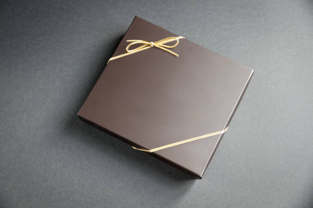 istock Black gift box with a golden ribbon on black background 1270565264