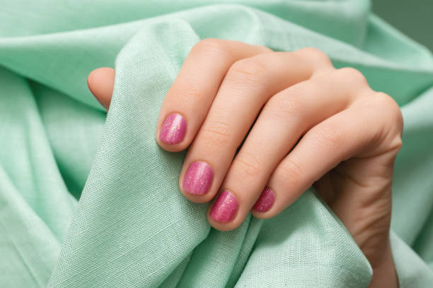 istock Female hand with pink glitter nail design 1270566464
