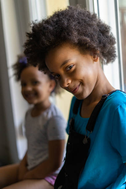istock Smiling little sisters looking at camera 1270567891