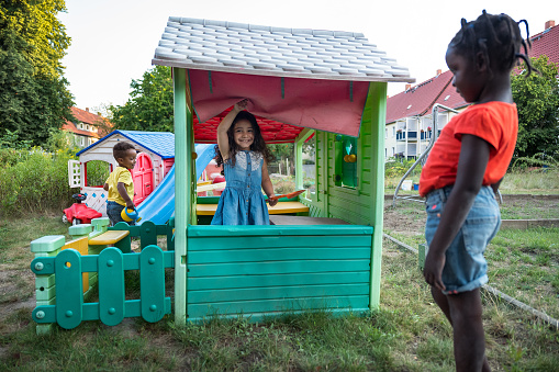 Children have fun in a playhouse in back yard