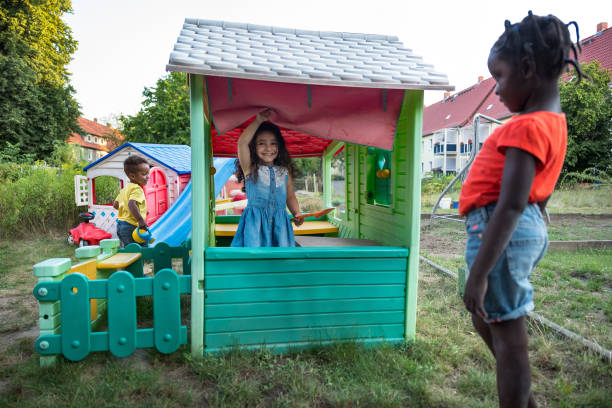 Children have fun in a playhouse in back yard Children have fun in a playhouse in back yard kids play house stock pictures, royalty-free photos & images
