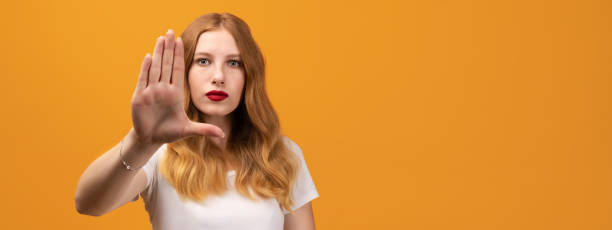 istock Young pretty woman with wavy redhead, showing open palm making stop gesture. Copy space 1270572538