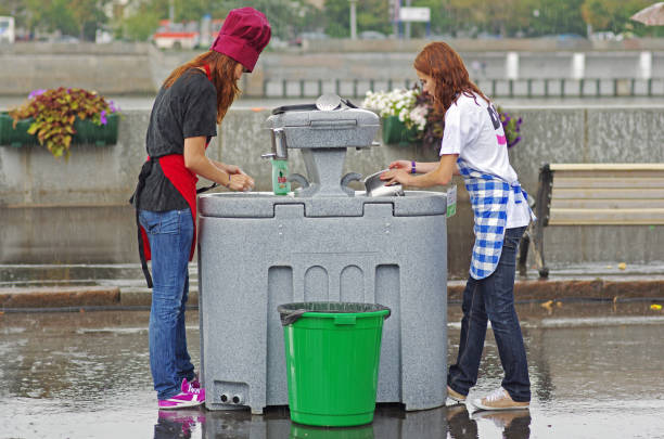 giovani donne che lavano i piatti con il tempo piovoso nel gorky park a mosca - wash stand foto e immagini stock