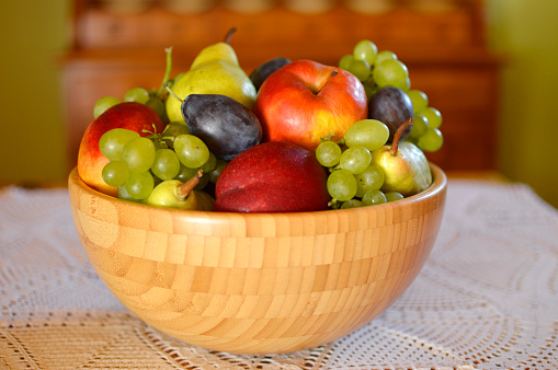 ripe grapes, pears, apples, plums and peaches in the bowl close up