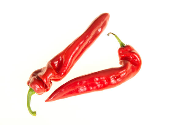 Two red pointed peppers isolated on a white background seen from a high angle view
