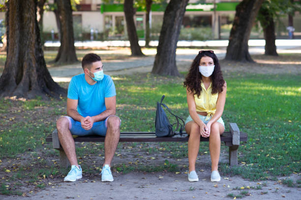 istock Young couple wearing protective face masks in the park 1270582283