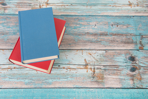 Red and blue book on a blue scaffolding wooden floor with space for copy