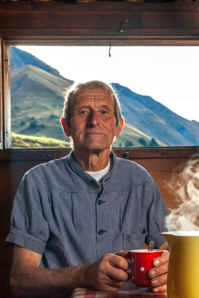 farmer drinking coffee in farmhouse, switzerland - home interior cabin shack european alps imagens e fotografias de stock