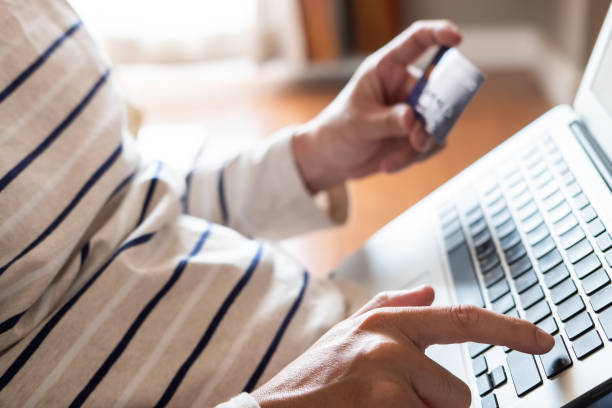 istock Selective focus at men hand pressing enter on keyboard. Close up shot at men while enter security key on credit card for online payment shopping. Wireless banking transaction via internet technology. 1270583165