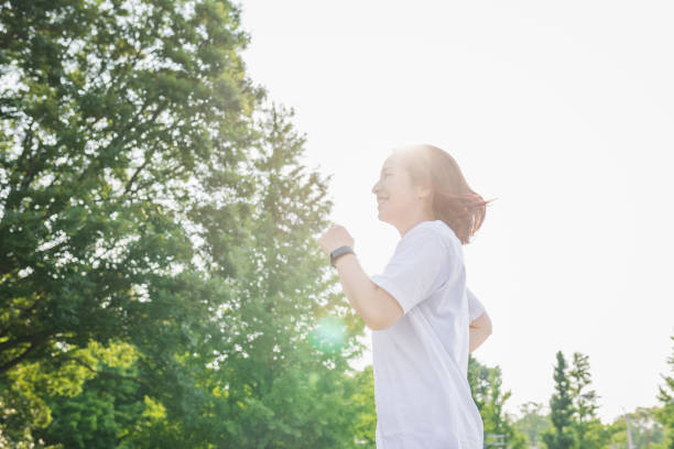 公園で走っている女性 - sport running exercising jogging ストックフォトと画像