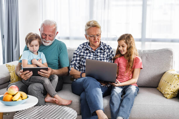 istock Senior people and their small grandchildren using wireless technology at home. 1270589411