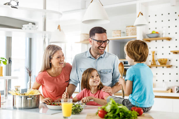 istock Young happy family talking while preparing a meal in the kitchen. 1270590732